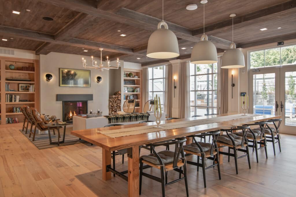 a large dining table with chairs and a fireplace in the background